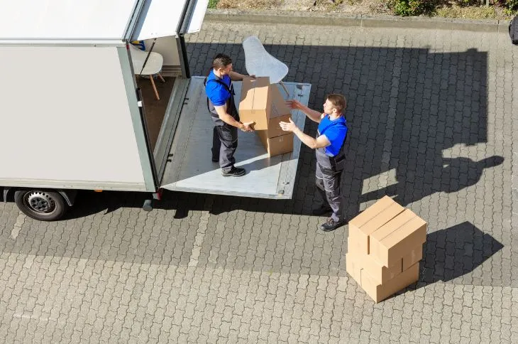 Umzugshelfer beim Entladen vor neuem Haus